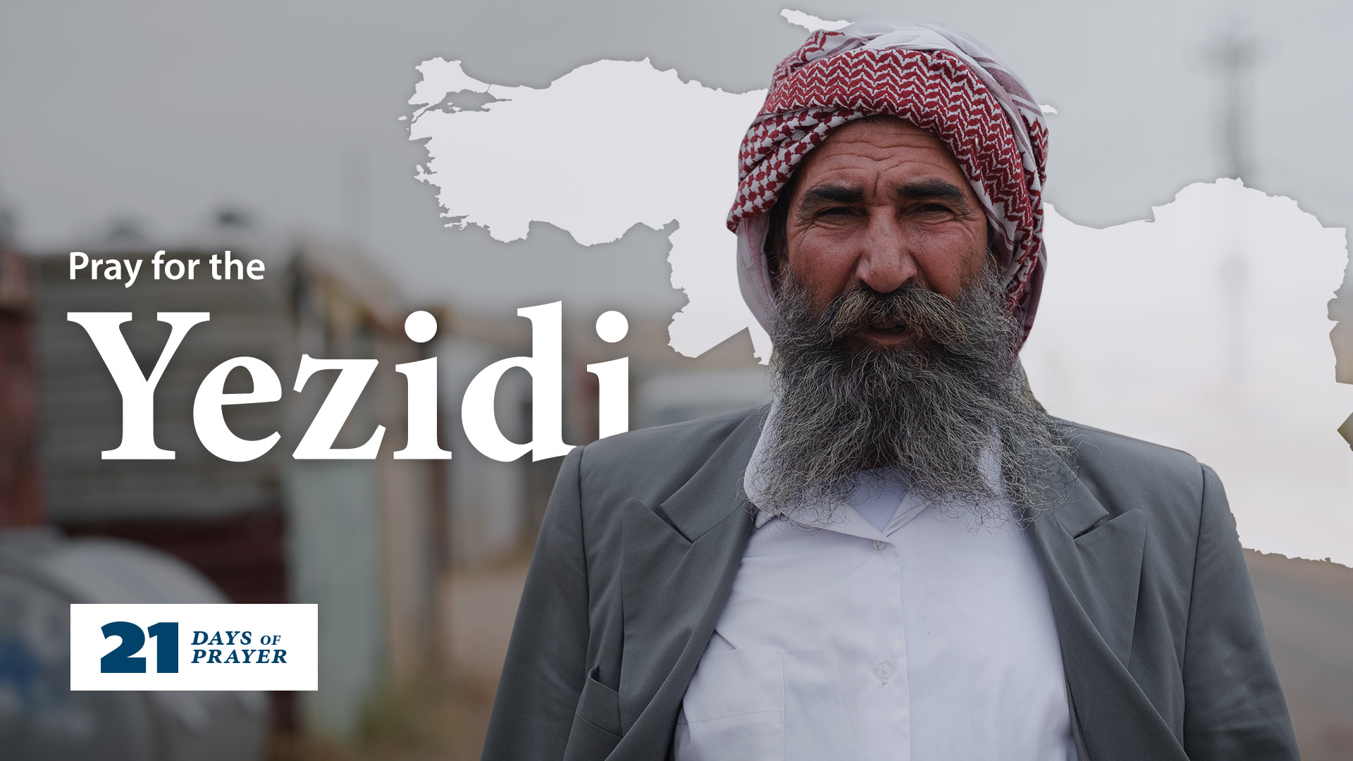 A Yezidi man with a big beard and turban looks into the camera. The text behind him reads 